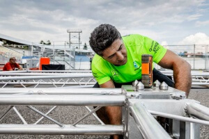 Mitarbeiter prüft Grid mit Laser-Messgerät
